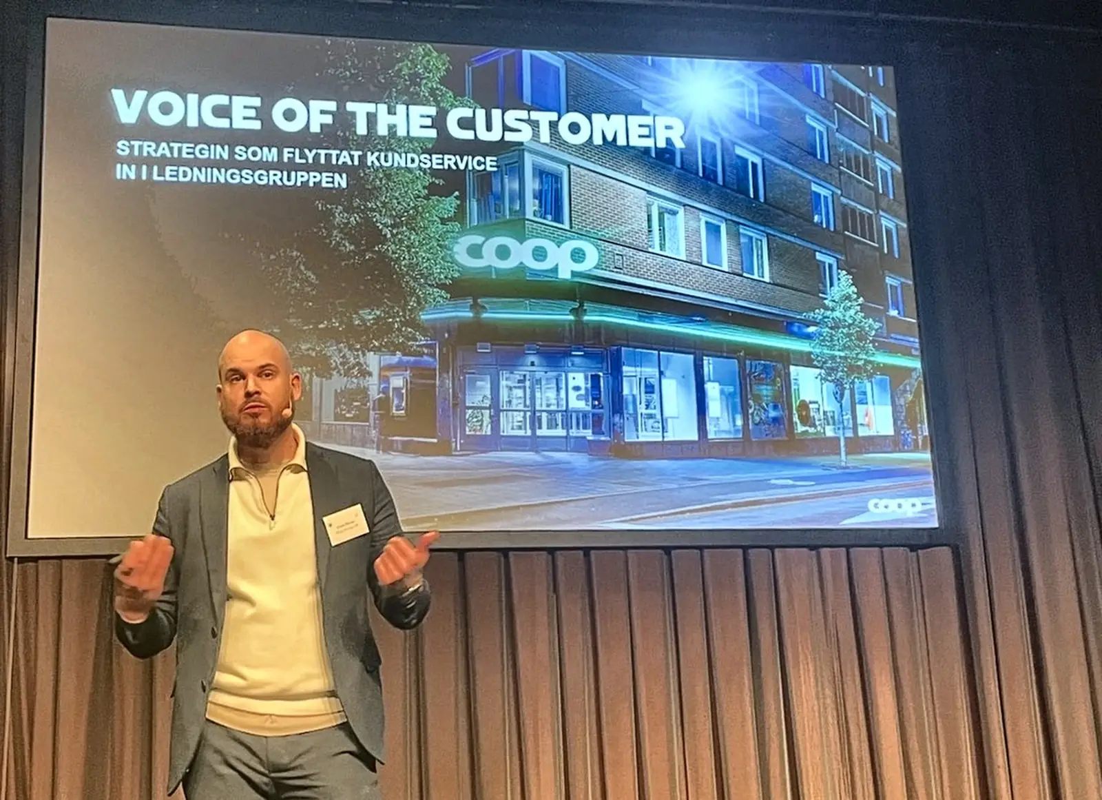 Chris Öhman på scen med presentationen Voice of the Customer: strategin som flyttat kundservice in i ledningsgruppen